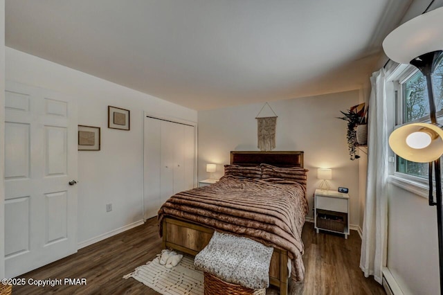 bedroom featuring a baseboard radiator, dark hardwood / wood-style flooring, and a closet