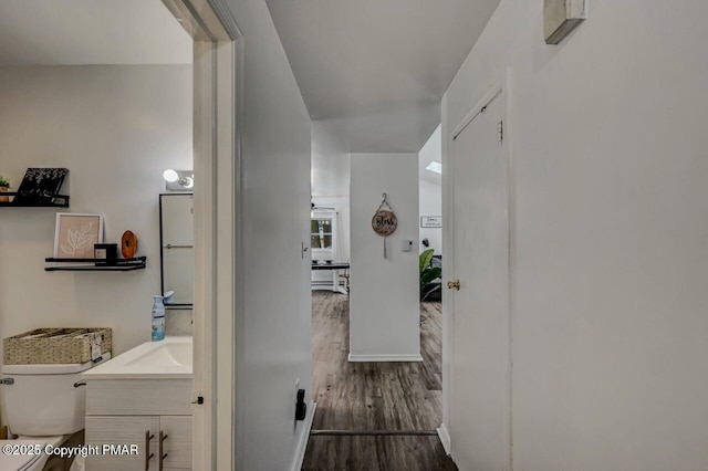 corridor with dark hardwood / wood-style floors and sink