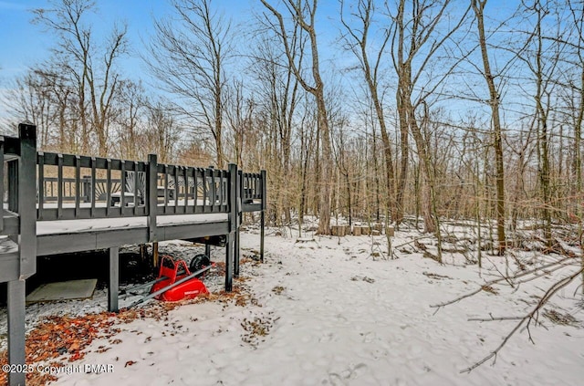 yard layered in snow featuring a wooden deck