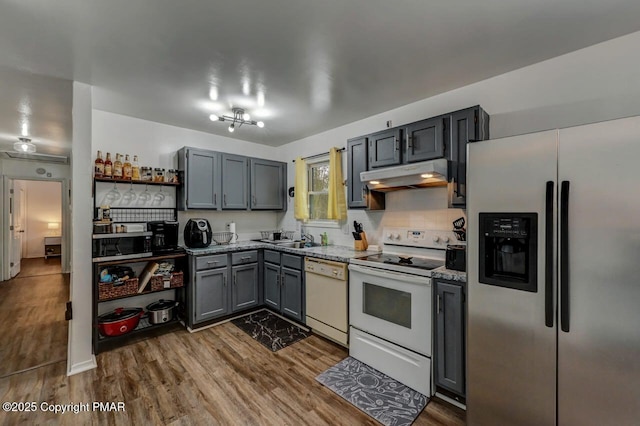 kitchen with white appliances, gray cabinetry, light stone counters, tasteful backsplash, and dark hardwood / wood-style flooring