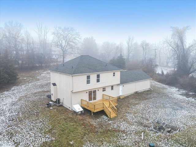 back of property with cooling unit, roof with shingles, and a wooden deck