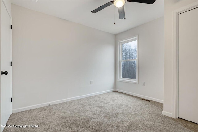 spare room featuring a ceiling fan, carpet flooring, visible vents, and baseboards