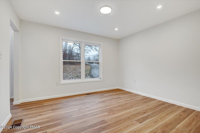 empty room featuring recessed lighting, light wood-style flooring, and baseboards