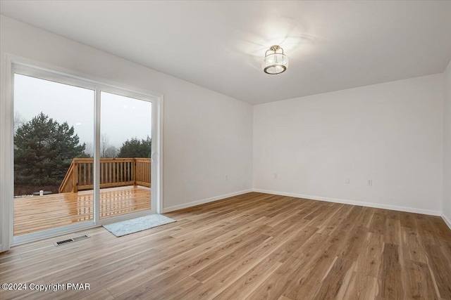 spare room with visible vents, baseboards, and wood finished floors