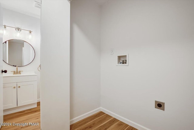 laundry area featuring hookup for a washing machine, light wood-style flooring, electric dryer hookup, laundry area, and baseboards