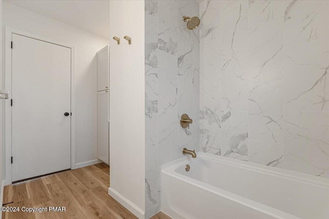 full bath with washtub / shower combination, baseboards, and wood finished floors