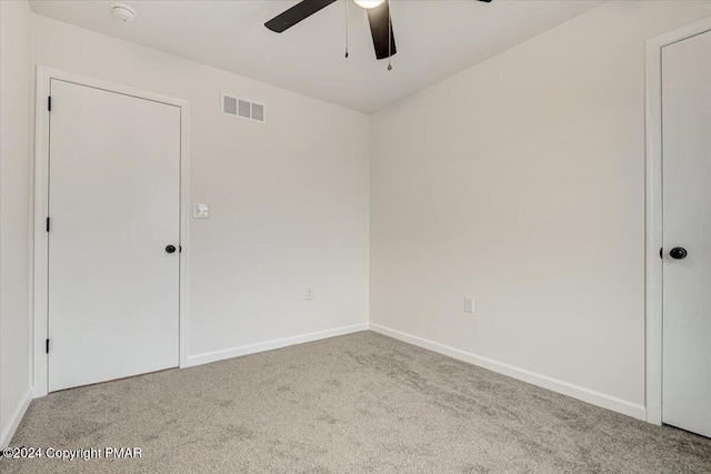 empty room featuring a ceiling fan, baseboards, visible vents, and carpet flooring