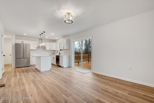 kitchen featuring appliances with stainless steel finishes, light wood-type flooring, light countertops, and white cabinetry