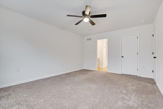 unfurnished bedroom with ceiling fan, carpet floors, visible vents, baseboards, and ensuite bath