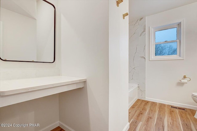 full bathroom featuring baseboards, visible vents, toilet, wood finished floors, and shower / washtub combination