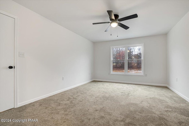 empty room with a ceiling fan, carpet, and baseboards