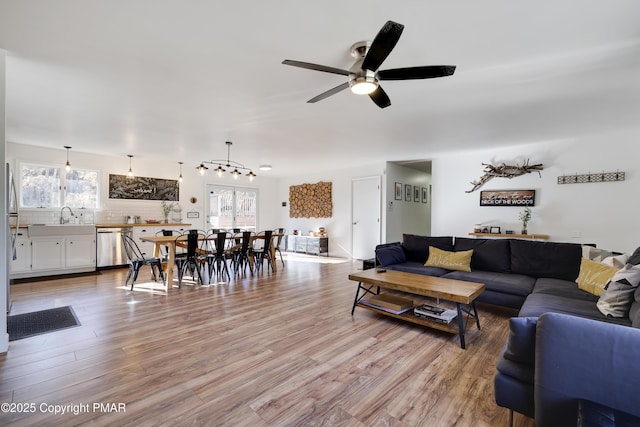 living room featuring ceiling fan, a wealth of natural light, sink, and light wood-type flooring