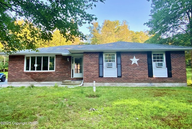 ranch-style house with cooling unit and a front lawn