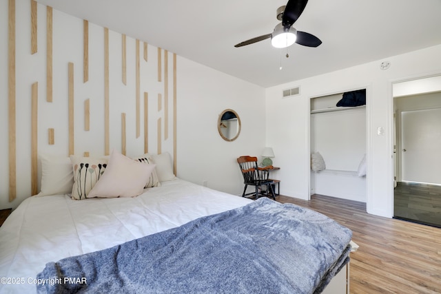 bedroom with hardwood / wood-style floors, a closet, and ceiling fan