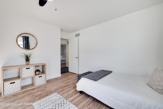 bedroom with light hardwood / wood-style floors and ceiling fan