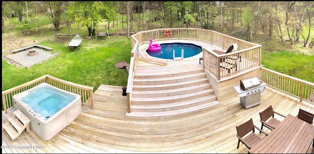 view of pool with a yard, an outdoor fire pit, grilling area, and a deck