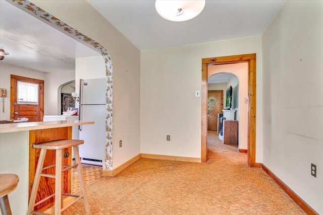 207 Scenic Dr, Kunkletown, PA 18058 - kitchen with freestanding refrigerator, arched walkways, a kitchen bar, light colored carpet, and light countertops