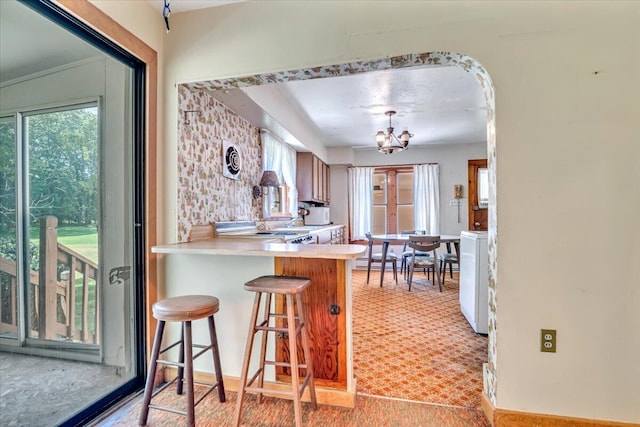207 Scenic Dr, Kunkletown, PA 18058 - kitchen with plenty of natural light, light countertops, a chandelier, and a kitchen bar
