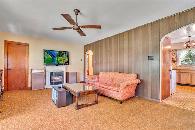 207 Scenic Dr, Kunkletown, PA 18058 - carpeted living area featuring arched walkways, ceiling fan, a lit fireplace, and wooden walls
