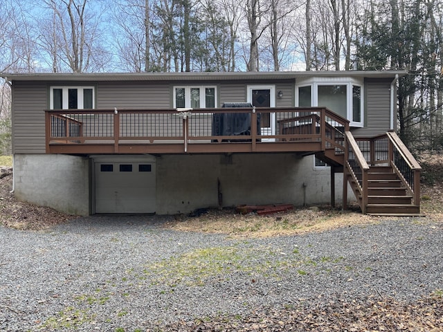 200 Onocop Dr, Pocono Lake, PA 18347 - back of property featuring driveway, stairway, an attached garage, and a wooden deck