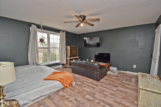 bedroom with a baseboard radiator, a ceiling fan, and wood finished floors