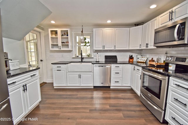 kitchen with dark wood-style floors, white cabinetry, stainless steel appliances, and a sink