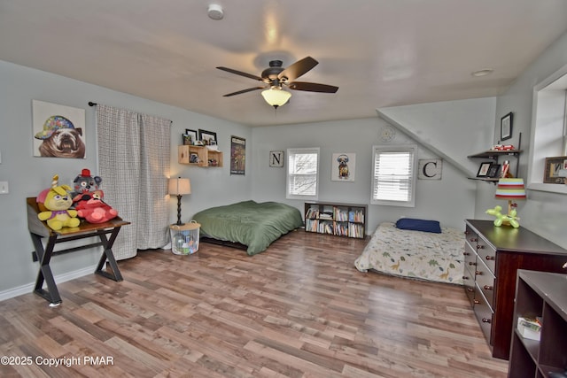 bedroom featuring ceiling fan, baseboards, and wood finished floors