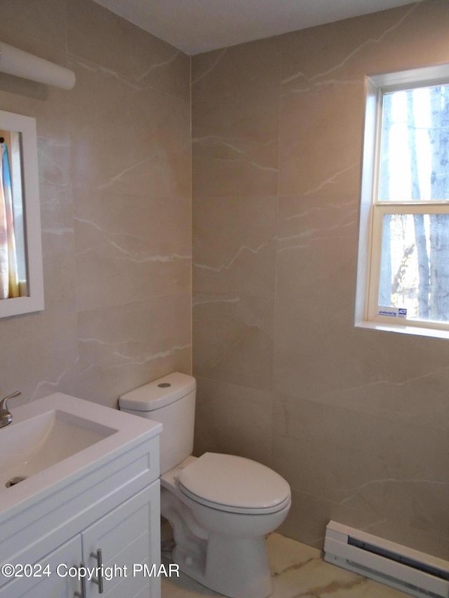 bathroom featuring toilet, vanity, marble finish floor, tile walls, and a baseboard radiator