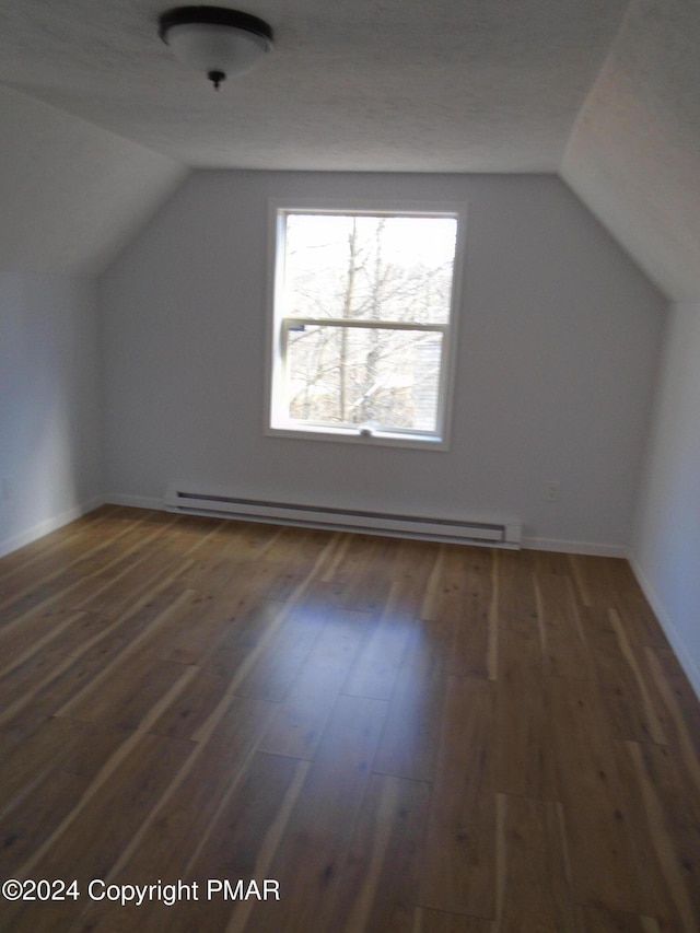 bonus room featuring a baseboard heating unit, lofted ceiling, baseboards, and wood finished floors