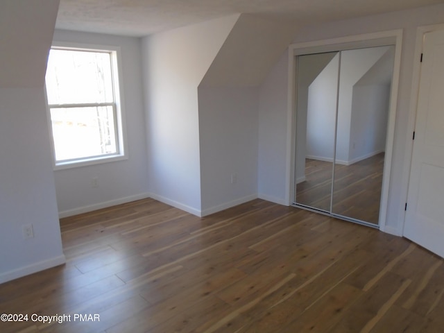 bonus room with wood finished floors and baseboards