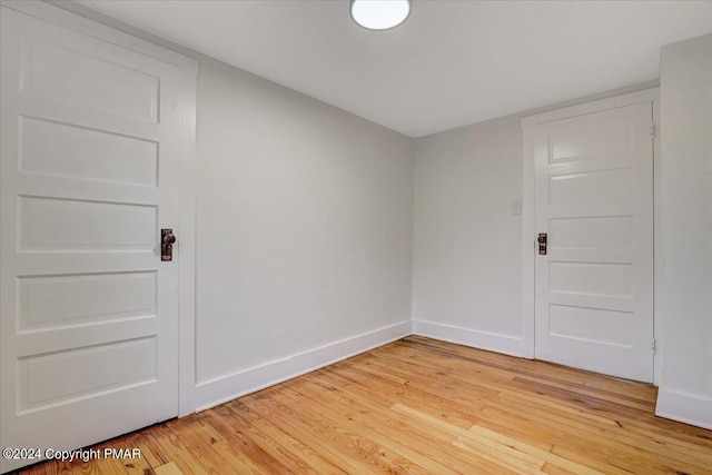 unfurnished room with light wood-type flooring and baseboards