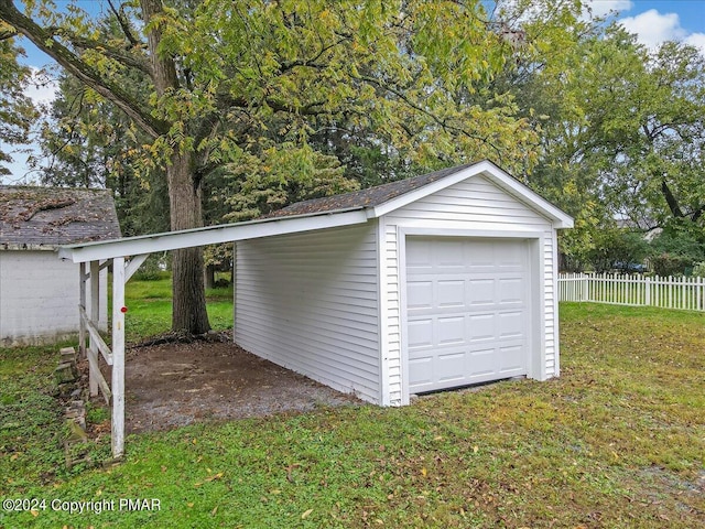 garage with a detached garage and fence