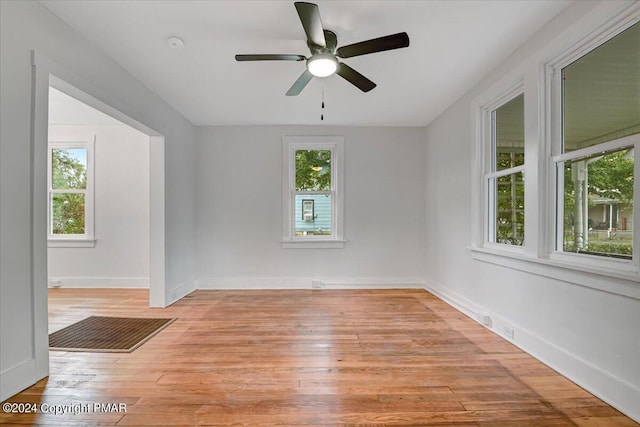 spare room with light wood-style floors, ceiling fan, and baseboards