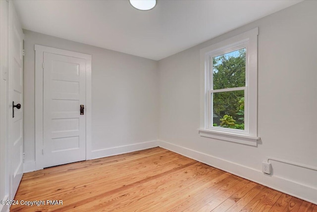 unfurnished room with light wood-type flooring and baseboards