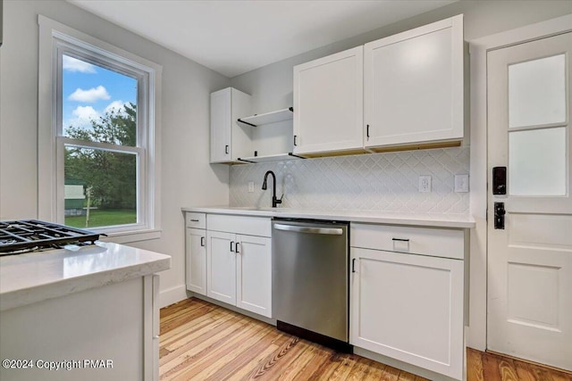 kitchen featuring a sink, white cabinetry, light countertops, stainless steel dishwasher, and open shelves