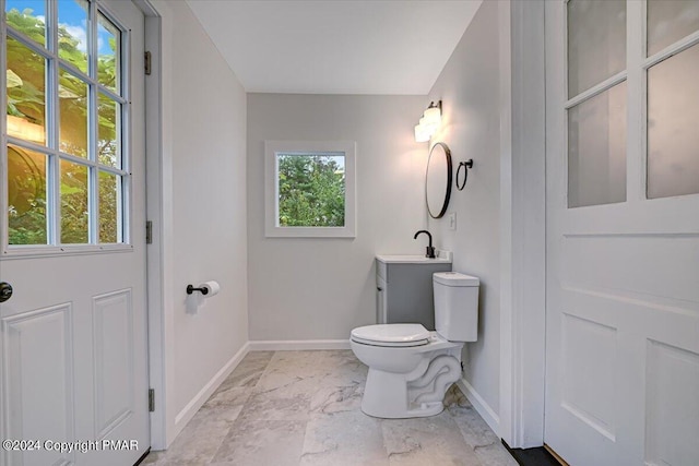 bathroom with marble finish floor, vanity, toilet, and baseboards