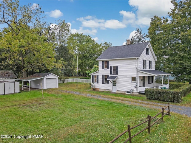 rear view of house featuring dirt driveway, a lawn, a chimney, an outbuilding, and fence