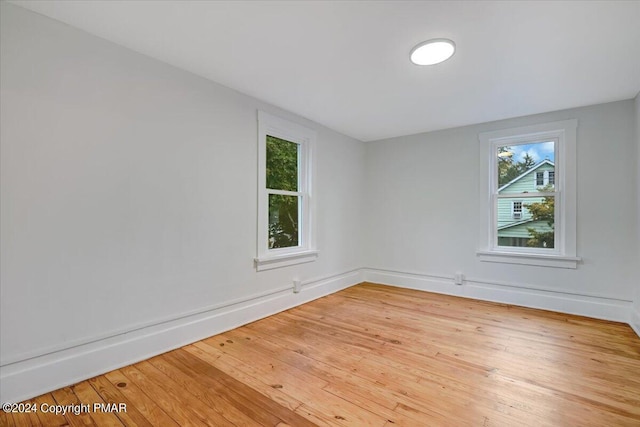 spare room with hardwood / wood-style flooring and baseboards