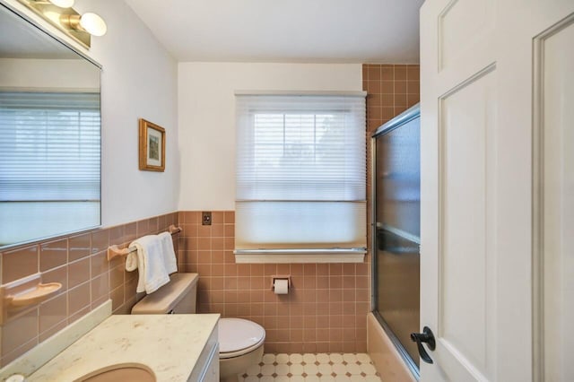 938 Meadow Cir, Bethlehem, PA 18017 - full bathroom with tile walls, vanity, shower / bath combination with glass door, a wainscoted wall, and tile patterned flooring