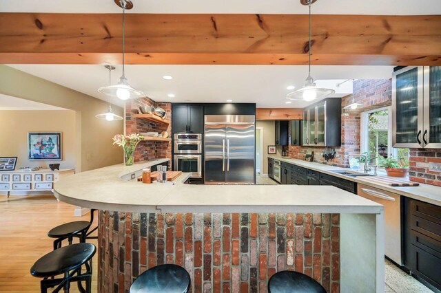 938 Meadow Cir, Bethlehem, PA 18017 - kitchen featuring appliances with stainless steel finishes, light countertops, tasteful backsplash, a breakfast bar, and glass insert cabinets