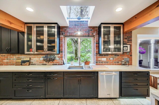 938 Meadow Cir, Bethlehem, PA 18017 - kitchen with dark aggregate flooring, light countertops, a skylight, and glass insert cabinets