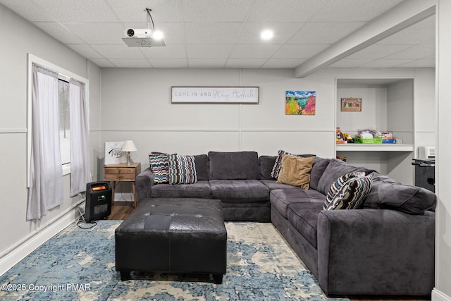 living room featuring a paneled ceiling and wood finished floors