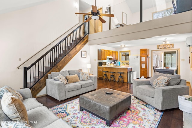 living area featuring stairs, dark wood-type flooring, and a wall mounted AC