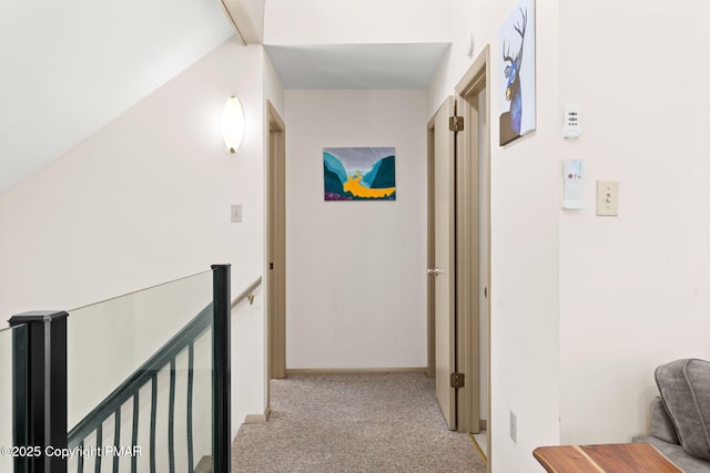 corridor featuring light carpet, an upstairs landing, and baseboards