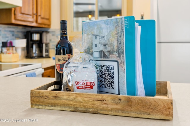 details with brown cabinetry, light countertops, decorative backsplash, and extractor fan