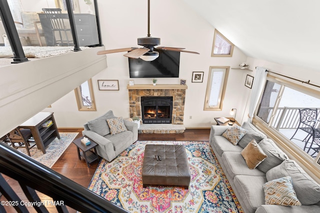 living area featuring high vaulted ceiling, a ceiling fan, a fireplace, and wood finished floors