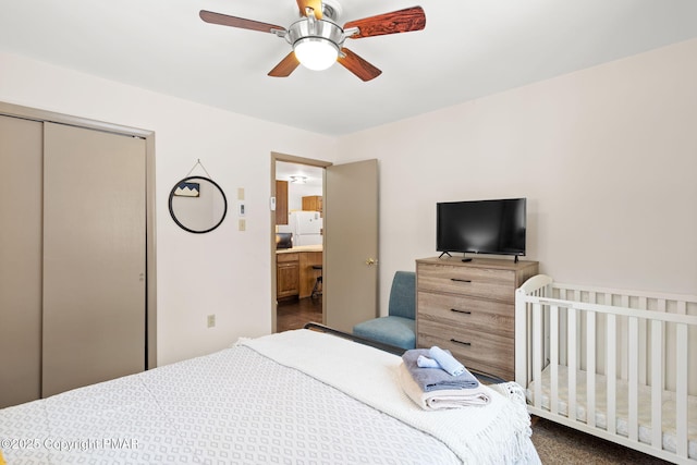 bedroom with freestanding refrigerator, a closet, and ceiling fan