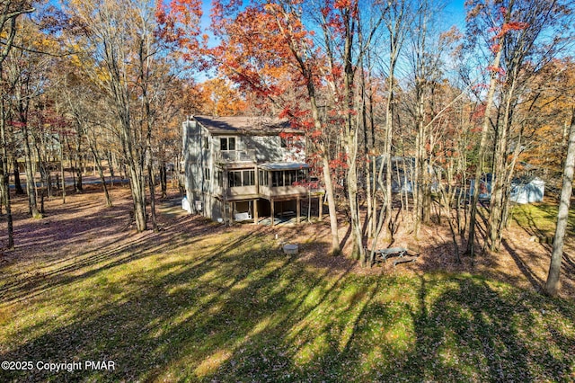 back of house featuring a lawn and a wooden deck