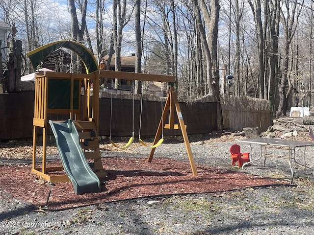 view of jungle gym featuring fence