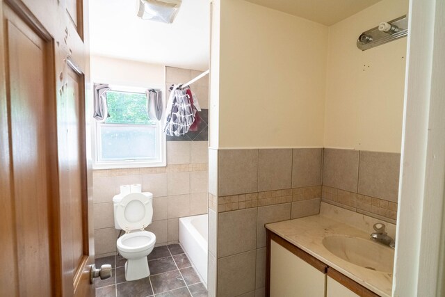 1206 Wooddale Rd, East Stroudsburg, PA 18302 - full bathroom featuring tile walls, toilet, tile patterned floors, vanity, and a wainscoted wall